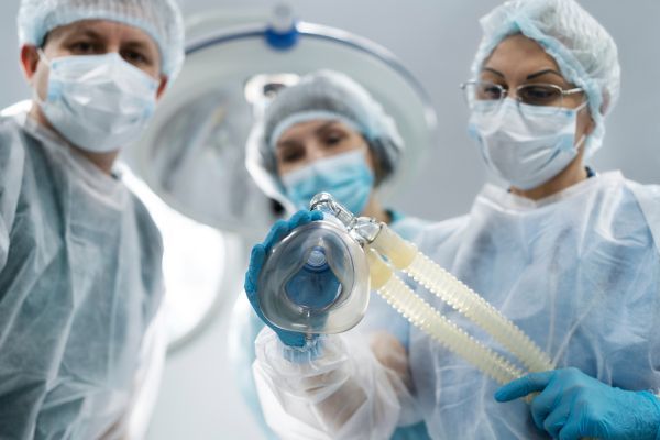 Pacientes recebendo anestesia na mesa de cirurgia.