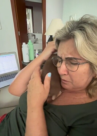 Emocionad,a a mãe pegou o filhote no colo.