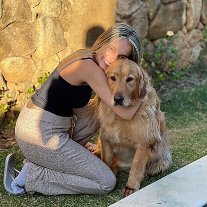 O golden retriever Jordan sendo abraçado por sua tutora.