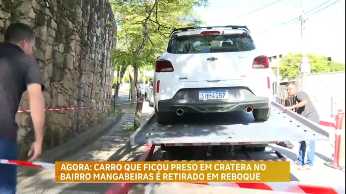 Carro preso em buraco que se abriu em rua de BH é retirado